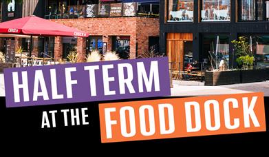 A photo showing an outside view of the Food Dock with the text: "Half Term at the Food Dock".