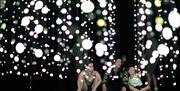 A family sitting together facing a massive light exhibit