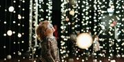 Child admiring bright lights in an art installation.